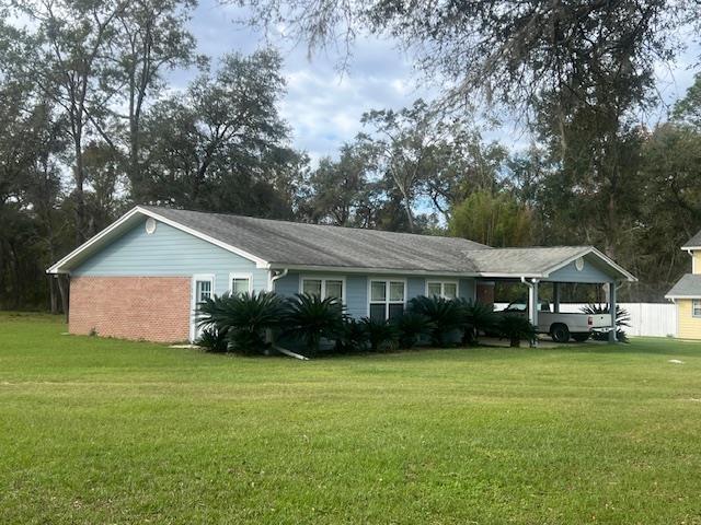 ranch-style house with a carport and a front yard