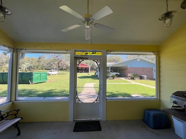 doorway featuring ceiling fan, a healthy amount of sunlight, and vaulted ceiling