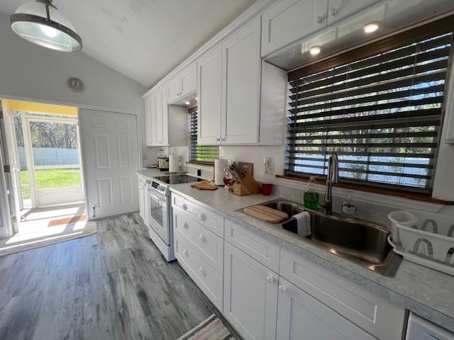 kitchen featuring white cabinetry, lofted ceiling, sink, white electric range oven, and light wood-type flooring