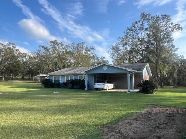 exterior space featuring a front lawn and a carport