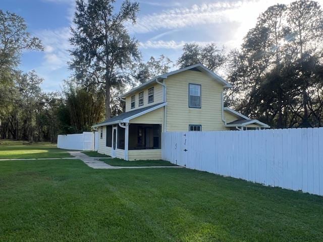 back of property with a yard and a sunroom