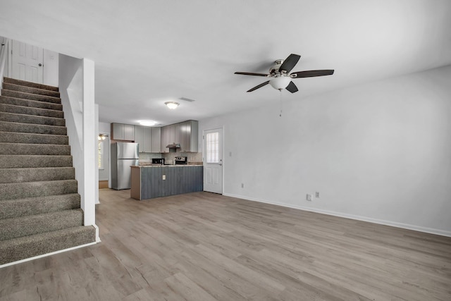 unfurnished living room with light hardwood / wood-style flooring and ceiling fan