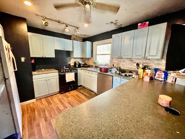 kitchen with backsplash, white cabinets, stainless steel dishwasher, light wood-type flooring, and black gas range oven