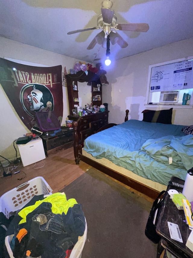 bedroom with hardwood / wood-style floors, ceiling fan, and cooling unit