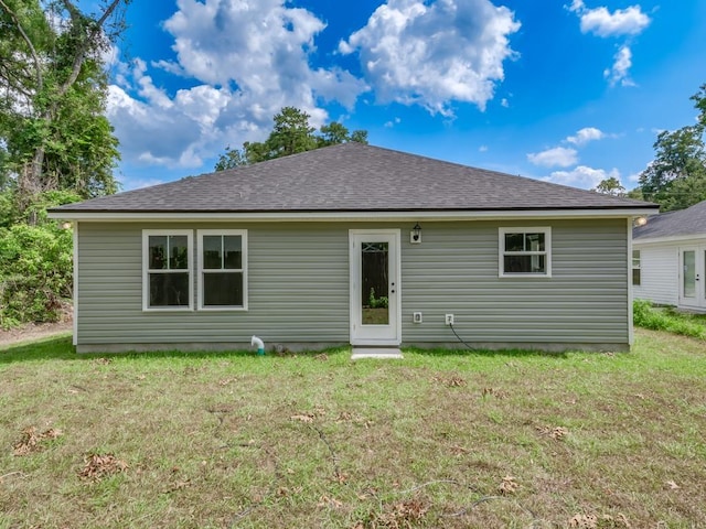 rear view of property featuring a lawn