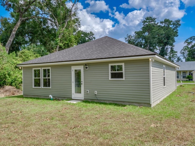 rear view of property featuring a lawn