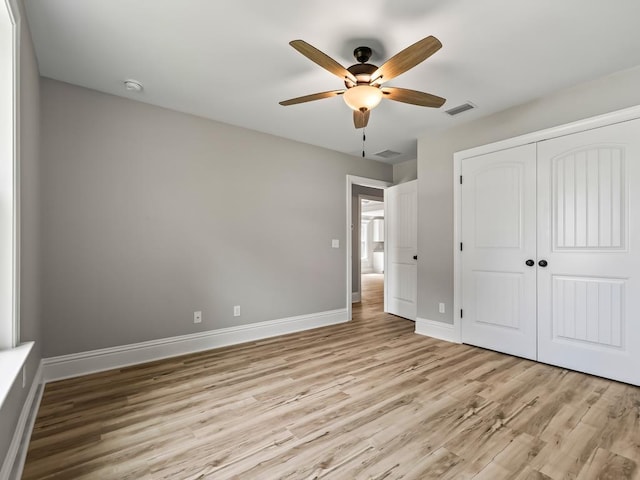 unfurnished bedroom featuring ceiling fan, a closet, and light wood-type flooring