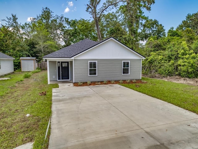 view of front of property with a shed and a front yard