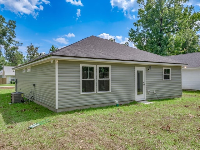 rear view of house featuring a yard and central air condition unit