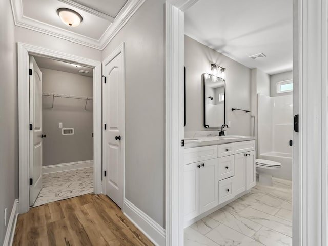 full bathroom featuring vanity, crown molding, bathtub / shower combination, and toilet