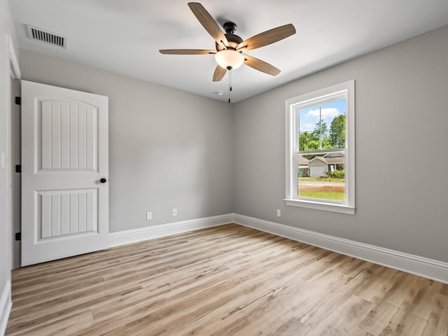 empty room with ceiling fan and light hardwood / wood-style flooring