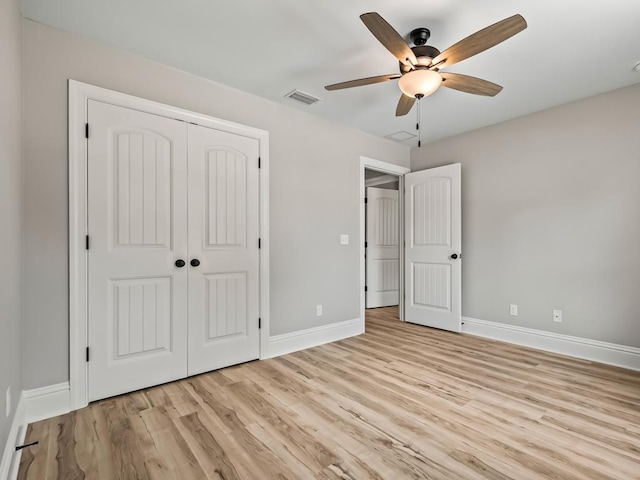 unfurnished bedroom featuring light hardwood / wood-style flooring, a closet, and ceiling fan