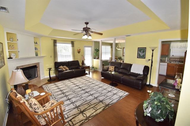 2736 Oakleigh Ct, Tallahassee, FL 32312 - living area featuring a raised ceiling, a ceiling fan, a fireplace, dark wood-style flooring, and built in features
