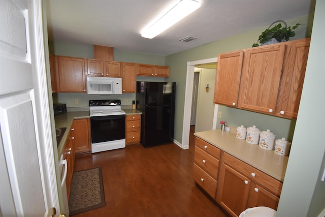 2736 Oakleigh Ct, Tallahassee, FL 32312 - kitchen with range with electric cooktop, freestanding refrigerator, white microwave, dark wood-style flooring, and light countertops