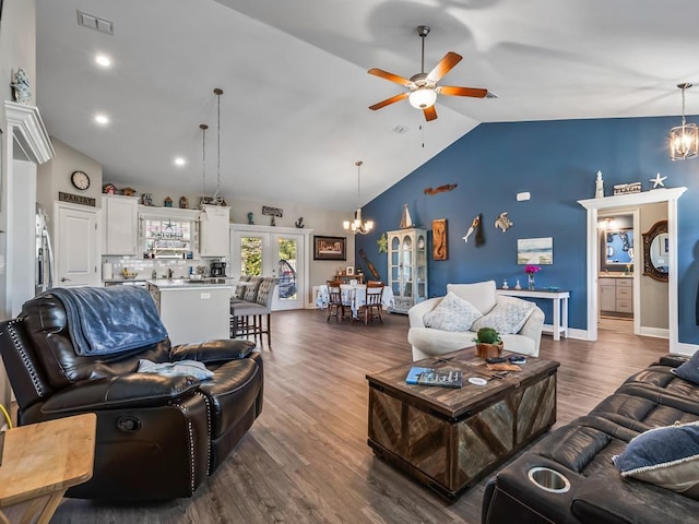 living room featuring ceiling fan with notable chandelier, lofted ceiling, dark hardwood / wood-style flooring, and french doors