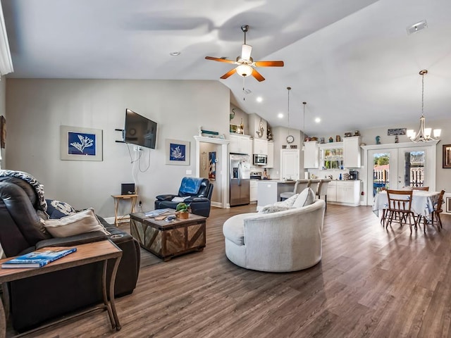 living room featuring french doors, dark wood-type flooring, high vaulted ceiling, and ceiling fan with notable chandelier