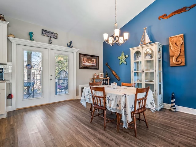 dining room featuring a notable chandelier, dark hardwood / wood-style floors, french doors, and lofted ceiling