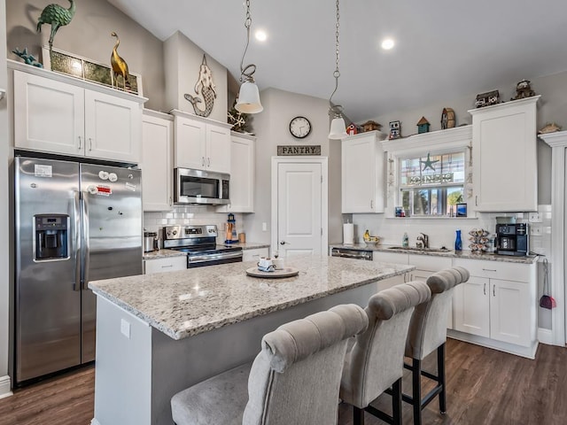 kitchen with white cabinetry, stainless steel appliances, pendant lighting, and a center island