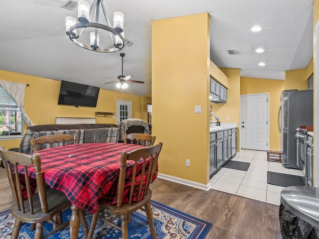 51 Mulberry Cir, Crawfordville, FL 32327 - dining room featuring a chandelier, light wood-type flooring, a textured ceiling, vaulted ceiling, and ceiling fan