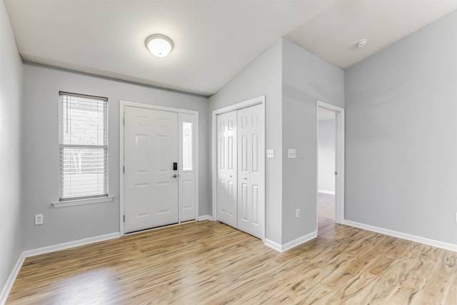 entrance foyer featuring vaulted ceiling and light hardwood / wood-style floors