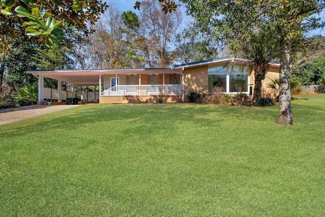 view of front facade with a carport, covered porch, and a front lawn