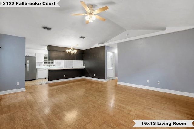 unfurnished living room featuring ceiling fan with notable chandelier, visible vents, baseboards, vaulted ceiling, and light wood-style floors