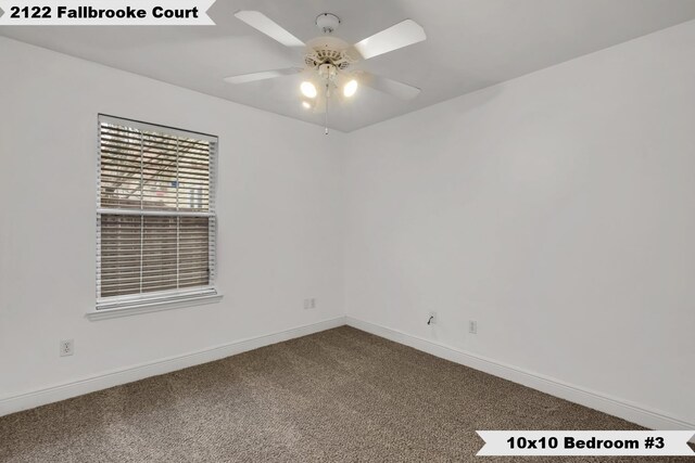 carpeted spare room featuring a ceiling fan and baseboards