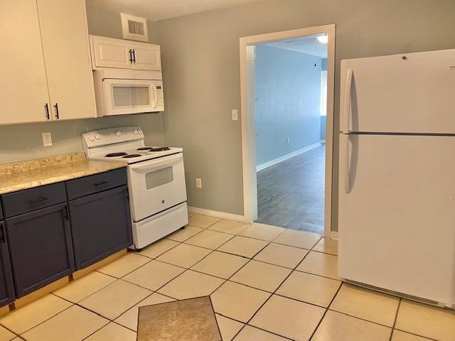 316-328 E Pershing St Unit 316-328, Tallahassee, FL 32301 - kitchen featuring light tile patterned floors, white appliances, and white cabinets