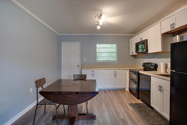 316-328 E Pershing St Unit 316-328, Tallahassee, FL 32301 - kitchen with crown molding, light hardwood / wood-style flooring, black appliances, and white cabinets