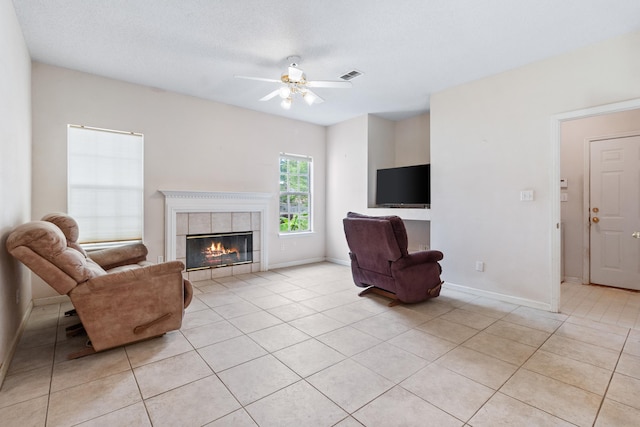 8827 Sapphire Dr, Tallahassee, FL 32309 - living area featuring light tile patterned flooring, a ceiling fan, a tile fireplace, and baseboards