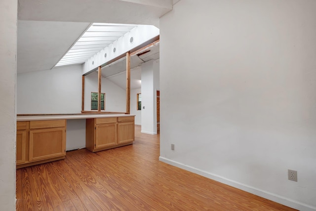3700 Honey Bee Pt, Tallahassee, FL 32309 - kitchen with light wood-style floors, built in study area, lofted ceiling, and light countertops