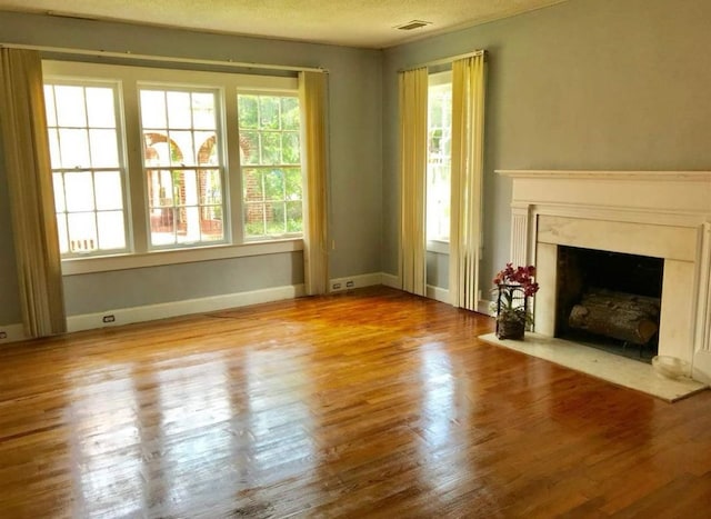 unfurnished living room featuring hardwood / wood-style floors and a textured ceiling