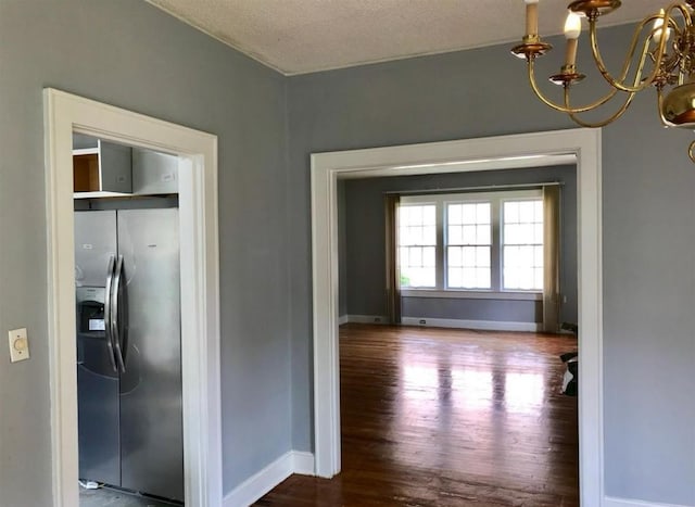 interior space with a chandelier, wood-type flooring, and a textured ceiling