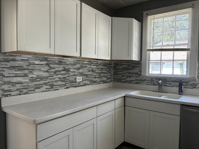 kitchen with white cabinetry, decorative backsplash, sink, and dishwasher