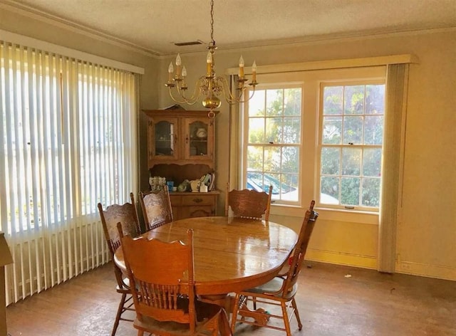 dining area with plenty of natural light, a notable chandelier, and a textured ceiling