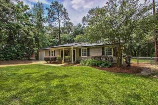 view of front of home with a front lawn, an attached garage, and fence