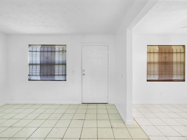 tiled entrance foyer featuring a textured ceiling