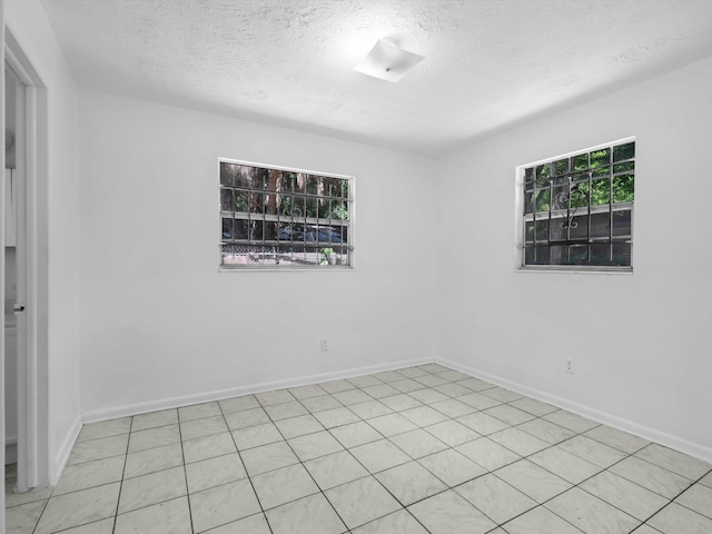 unfurnished room with a textured ceiling