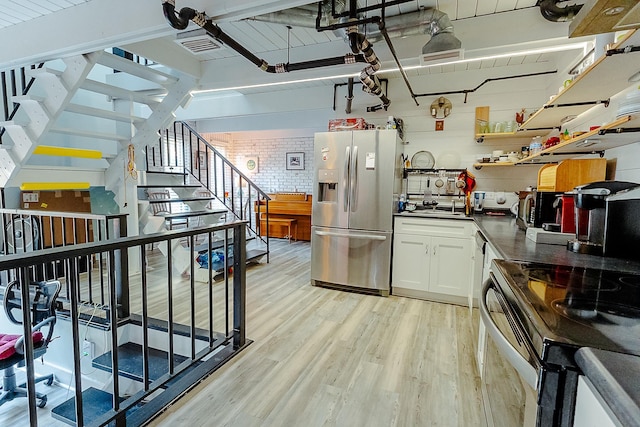220 Belmont Rd Unit 3, Tallahassee, FL 32301 - kitchen with stainless steel appliances, dark countertops, light wood-style flooring, white cabinetry, and open shelves