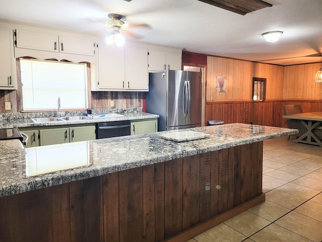 kitchen featuring dishwasher, stone counters, stainless steel fridge, white cabinets, and sink