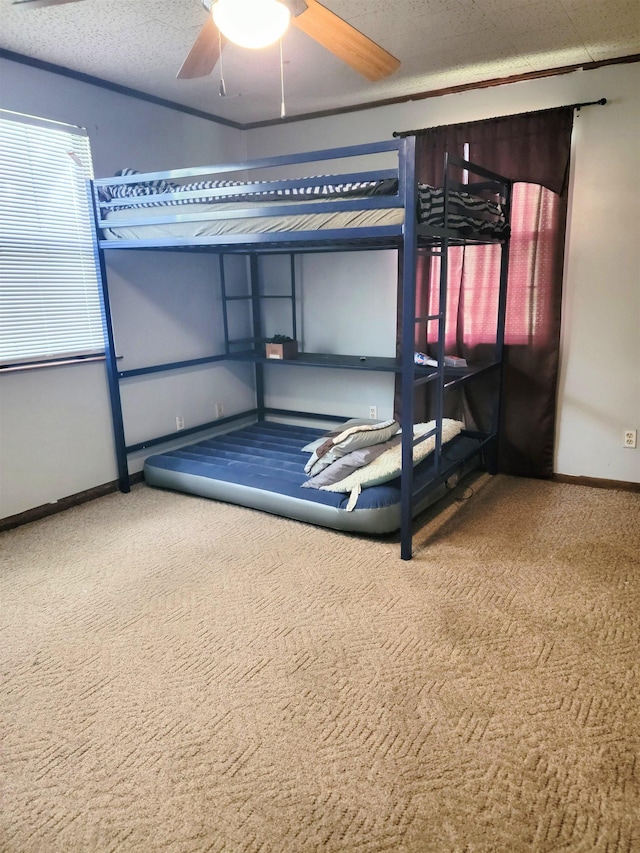 unfurnished bedroom featuring ceiling fan, carpet, and a textured ceiling