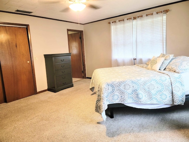 bedroom with light carpet, ceiling fan, and crown molding