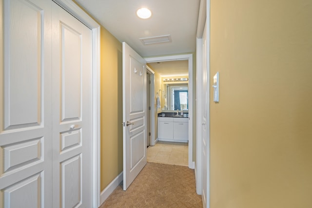 hall featuring a sink, visible vents, and baseboards