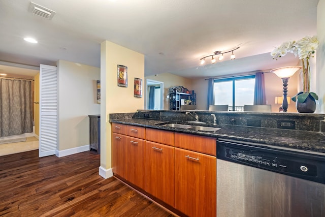 kitchen featuring dark wood-style flooring, visible vents, a sink, dark stone counters, and dishwasher