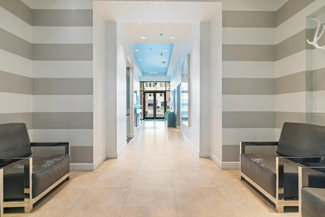 corridor with baseboards and light tile patterned floors