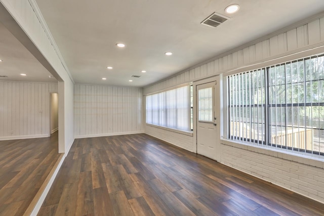 empty room featuring dark hardwood / wood-style floors and crown molding