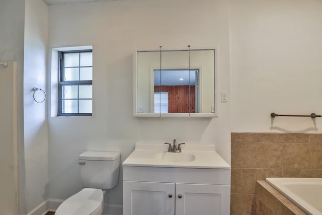 bathroom with a bathtub, vanity, and toilet