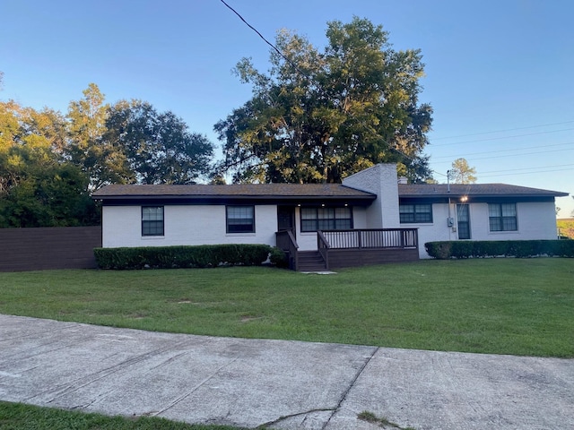 single story home featuring a front lawn and a deck