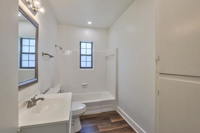 full bathroom featuring toilet, vanity, wood-type flooring, and tiled shower / bath