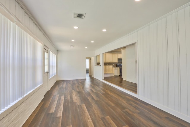 unfurnished living room featuring dark hardwood / wood-style floors and crown molding